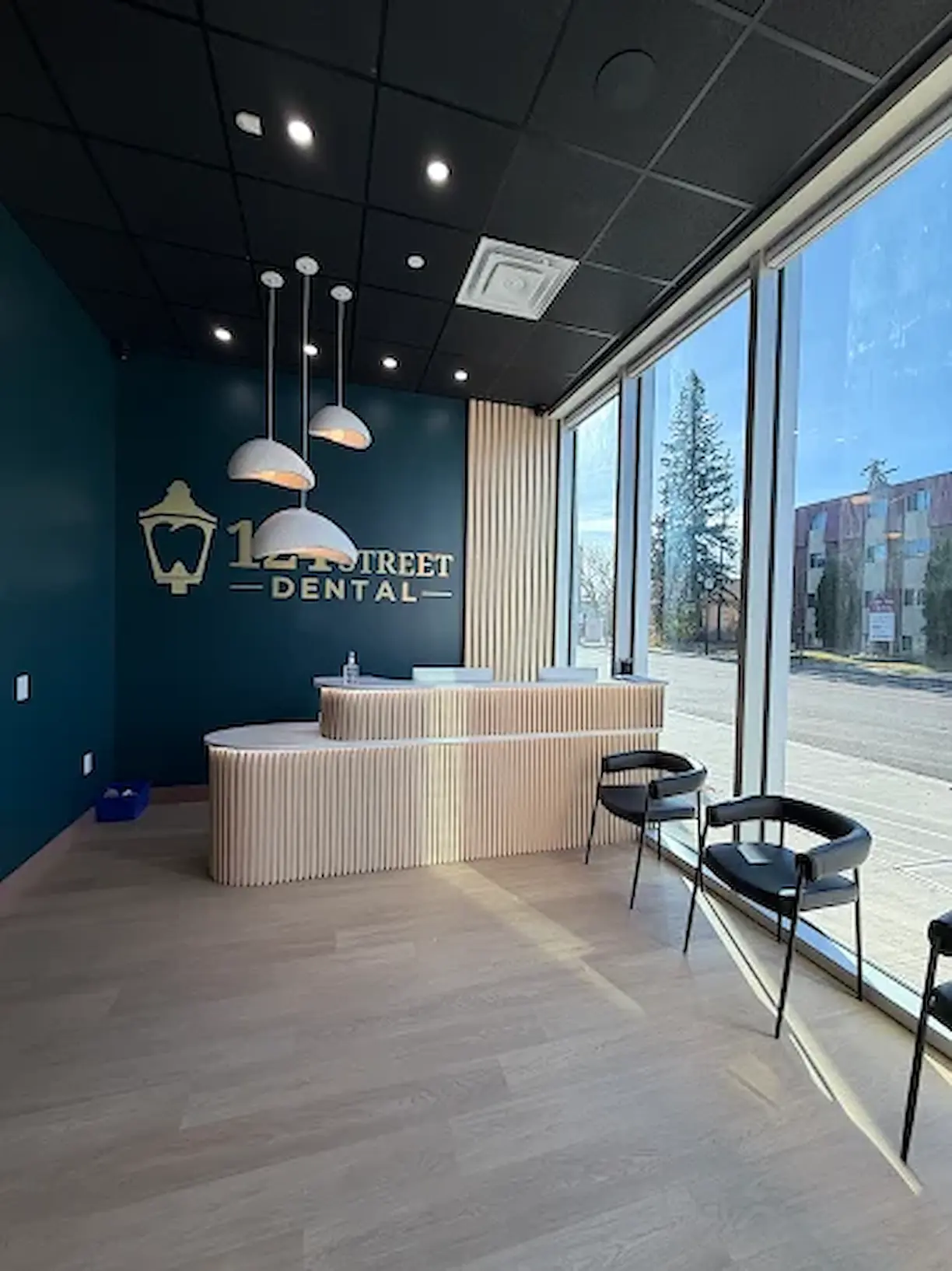 Reception and waiting area at 124 Street Dental, with floor-to-ceiling windows onto 124 Street in Edmonton